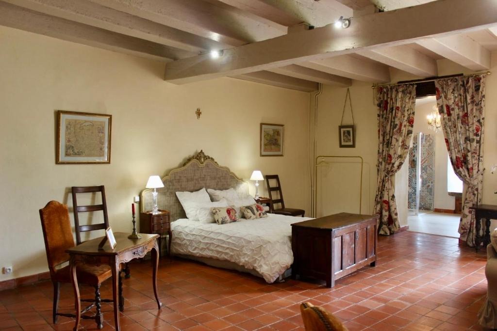 La chambre depuis l'entrée, rideaux fleuris et coffre ancien