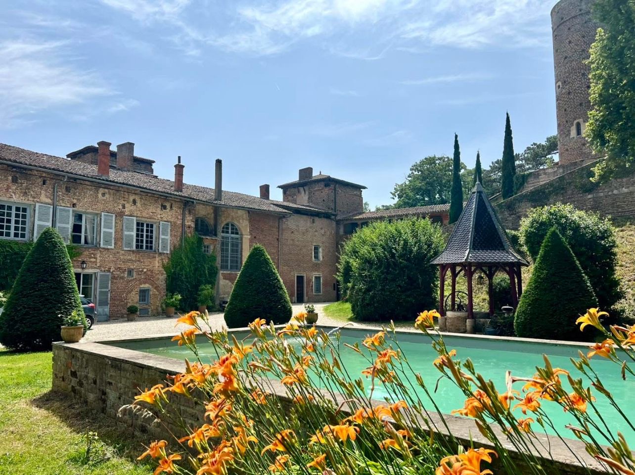 Jardins fleuris et bassin devant les façades du château